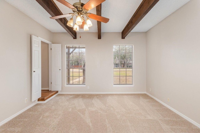 carpeted empty room featuring beamed ceiling, a textured ceiling, baseboards, and ceiling fan