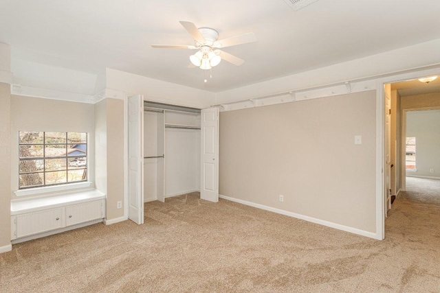 unfurnished bedroom with a ceiling fan, a closet, light colored carpet, and baseboards