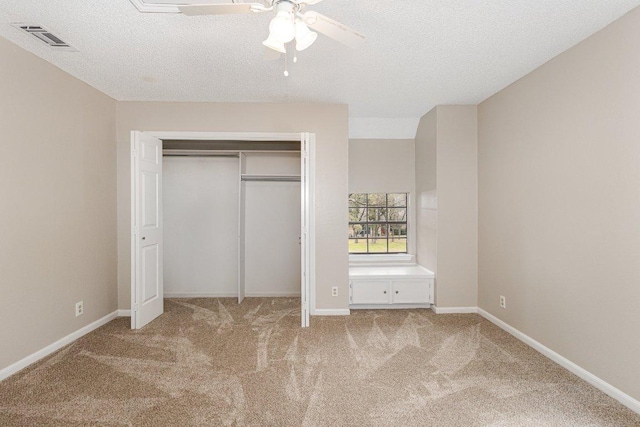 unfurnished bedroom featuring light carpet, baseboards, visible vents, a textured ceiling, and a closet