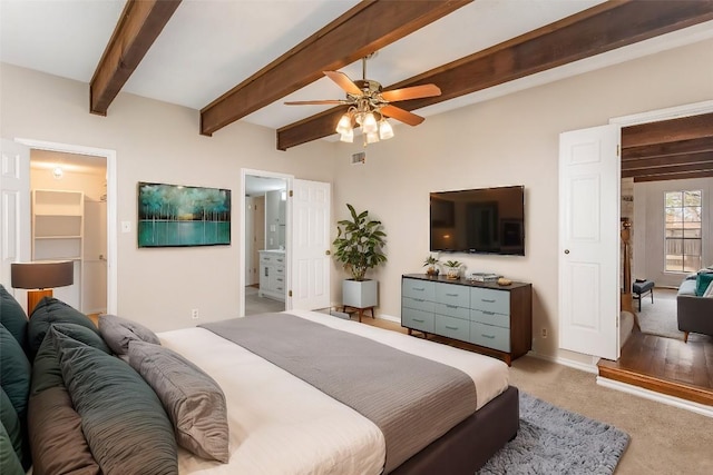 bedroom featuring light carpet, visible vents, baseboards, ensuite bath, and beam ceiling