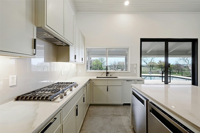 kitchen featuring a healthy amount of sunlight, tasteful backsplash, appliances with stainless steel finishes, and a sink