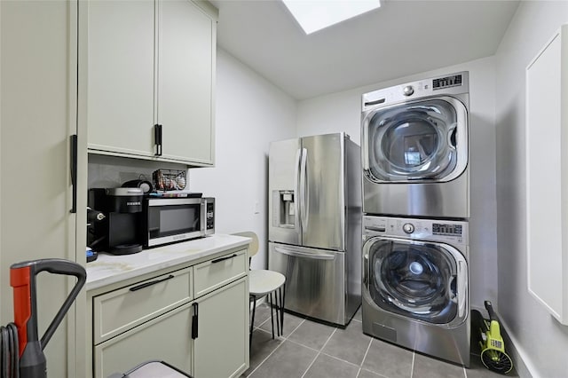 washroom with stacked washer and dryer, tile patterned flooring, and laundry area