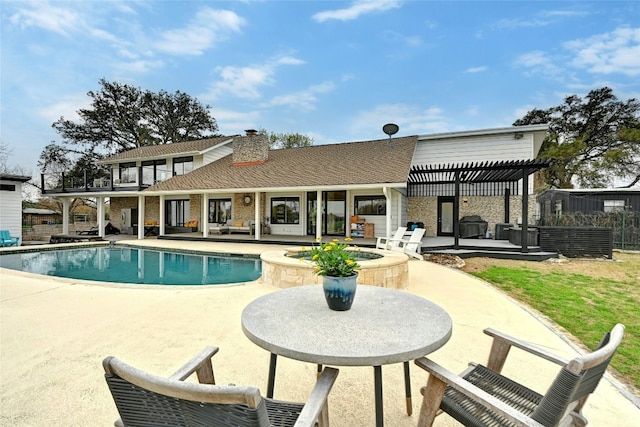 view of swimming pool with a pool with connected hot tub, a patio, and a pergola