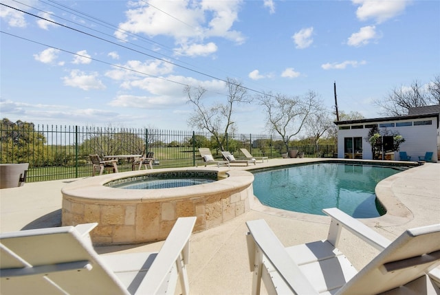 view of pool featuring a patio area, fence, and a pool with connected hot tub