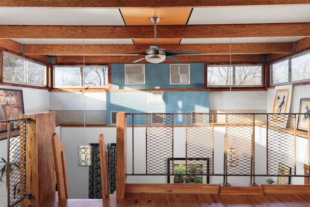 interior details with a ceiling fan, arched walkways, beam ceiling, and wood finished floors