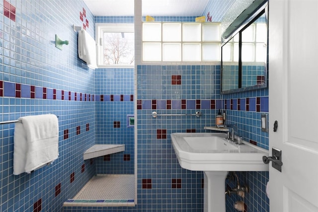 bathroom with a wealth of natural light, tiled shower, and tile walls