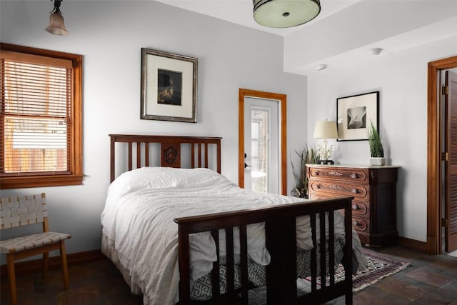 bedroom featuring stone finish floor and baseboards