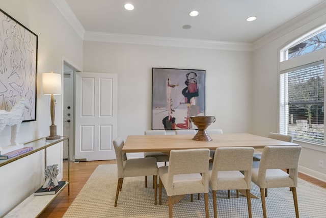 dining space featuring light wood finished floors, recessed lighting, and crown molding