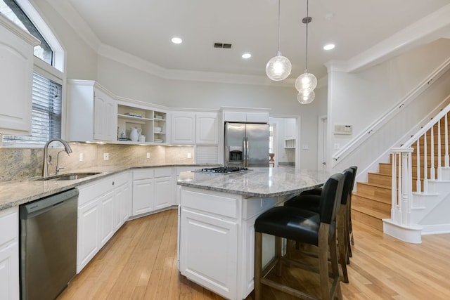 kitchen featuring open shelves, stainless steel appliances, visible vents, backsplash, and a sink