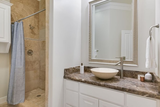 bathroom featuring tiled shower and vanity