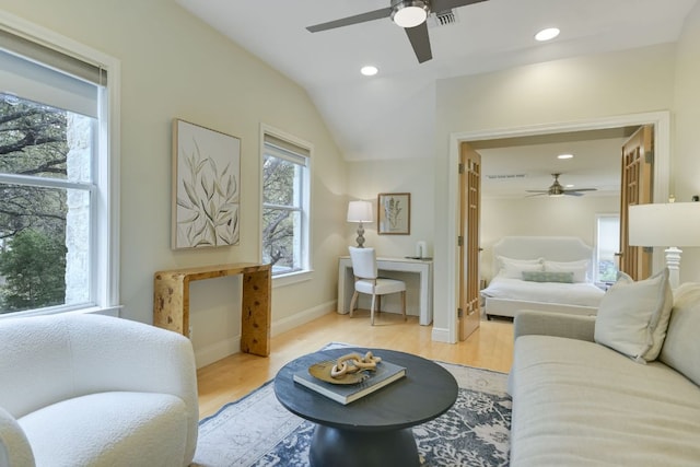 living room featuring recessed lighting, visible vents, lofted ceiling, and light wood finished floors