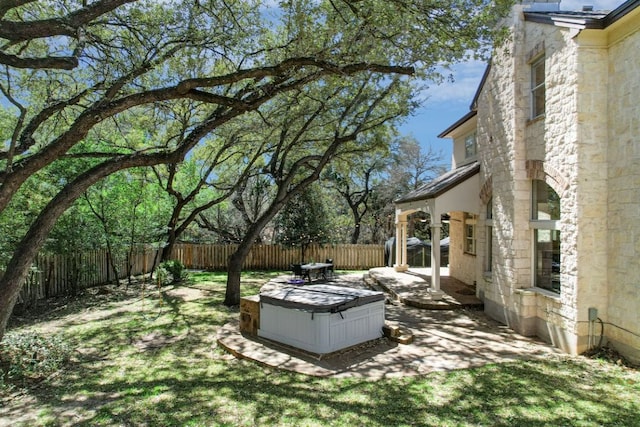 view of yard featuring a patio area, a fenced backyard, and a hot tub