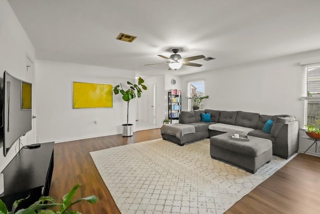 living room with plenty of natural light, visible vents, and dark wood finished floors