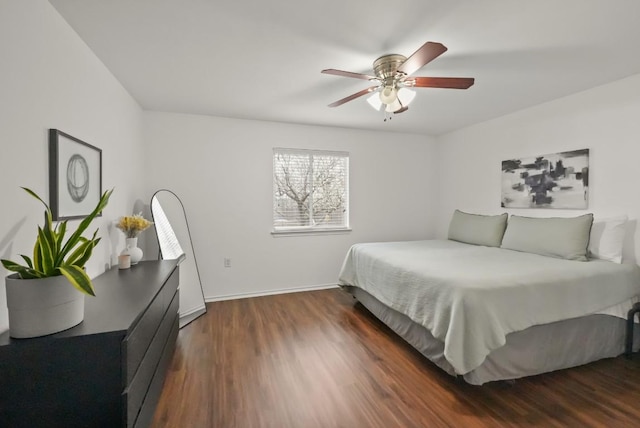 bedroom featuring dark wood-type flooring, a ceiling fan, and baseboards