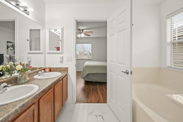 full bath with marble finish floor, a sink, and a healthy amount of sunlight