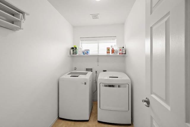 laundry room with light tile patterned floors, laundry area, and washing machine and dryer