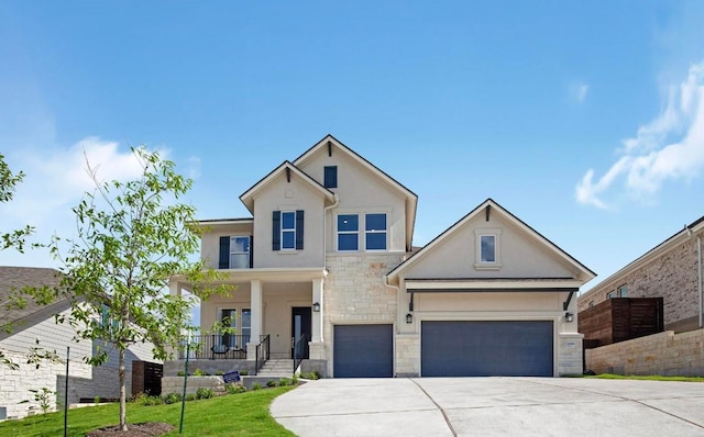 view of front of property featuring a porch, stone siding, stucco siding, and driveway