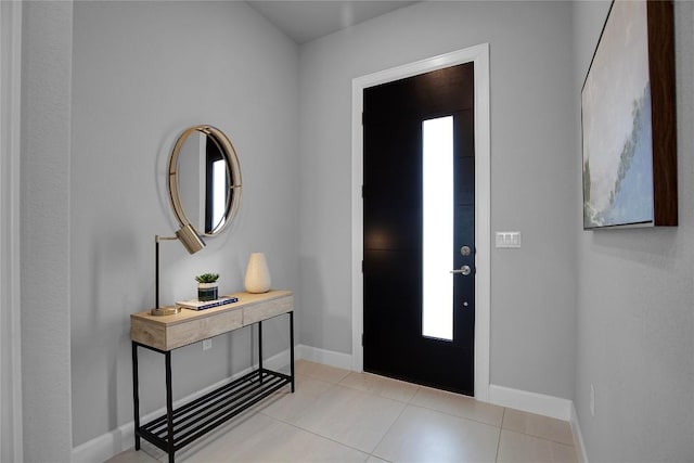 foyer entrance featuring light tile patterned flooring and baseboards