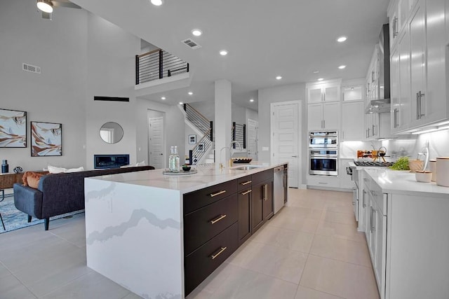 16909 Roselin Dr, Austin, TX 78738 - kitchen with a sink, appliances with stainless steel finishes, light tile patterned flooring, white cabinetry, and recessed lighting