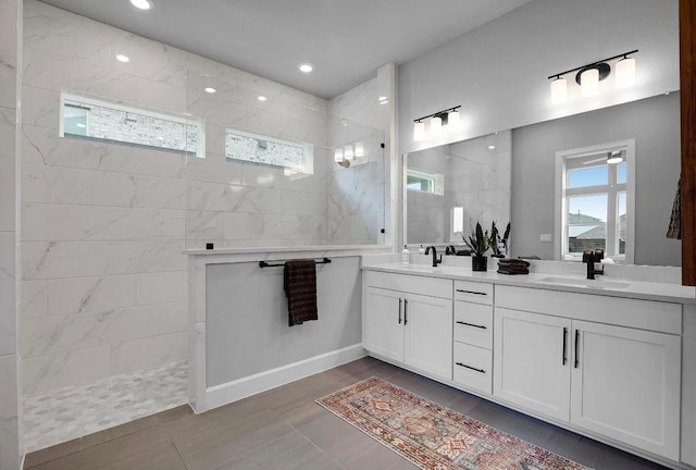 bathroom featuring double vanity, a wealth of natural light, walk in shower, and a sink