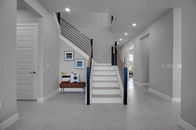 stairs featuring tile patterned flooring, recessed lighting, and baseboards