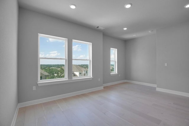 unfurnished room with recessed lighting, visible vents, plenty of natural light, and light wood finished floors