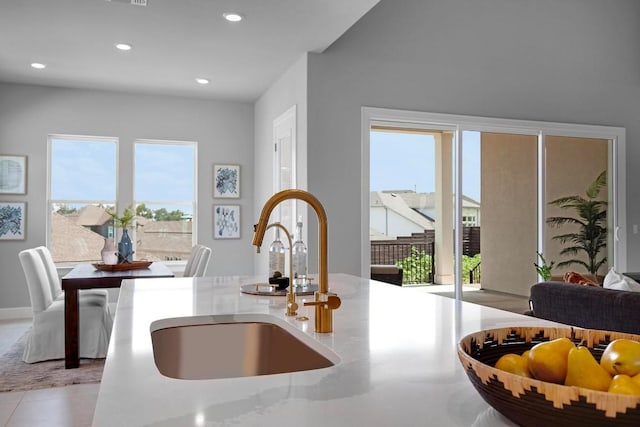 kitchen with recessed lighting, a sink, light countertops, tile patterned floors, and open floor plan