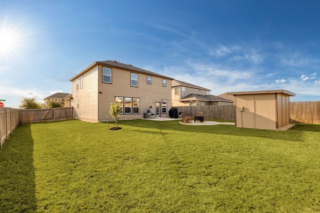 back of property featuring a yard, a patio, a storage unit, a fenced backyard, and an outdoor structure