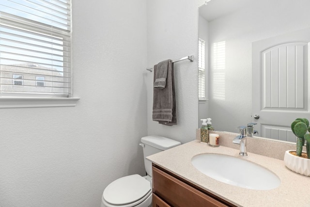 bathroom featuring toilet and vanity