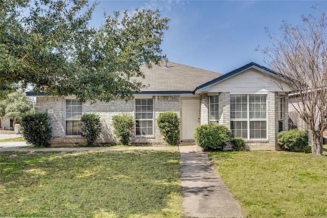 ranch-style home with brick siding and a front yard