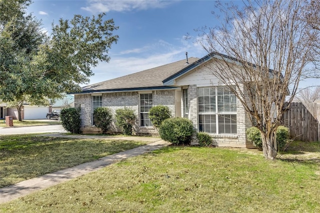 single story home featuring brick siding, fence, and a front lawn