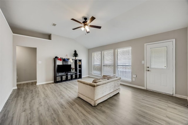 living room with lofted ceiling, wood finished floors, visible vents, baseboards, and a ceiling fan