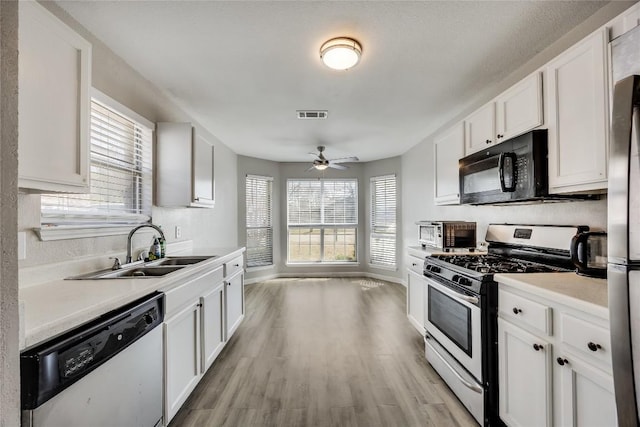 kitchen with appliances with stainless steel finishes, plenty of natural light, visible vents, and a sink