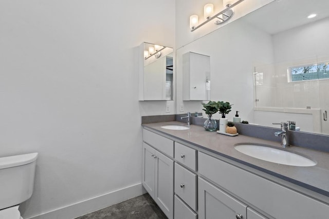 full bathroom with a tile shower, a sink, toilet, and baseboards