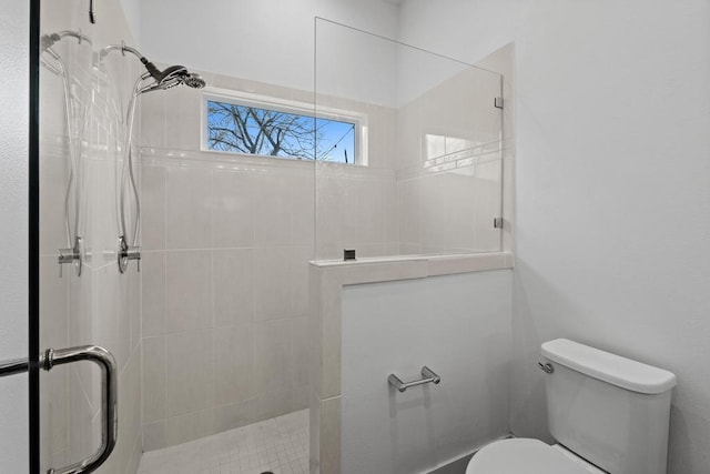 full bath with toilet and tiled shower