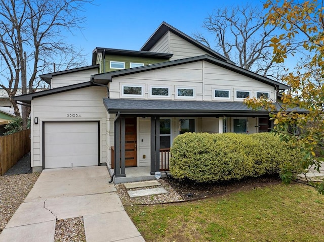 view of front facade featuring a garage, driveway, a shingled roof, and fence