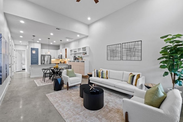 living area featuring finished concrete flooring, visible vents, baseboards, a ceiling fan, and recessed lighting