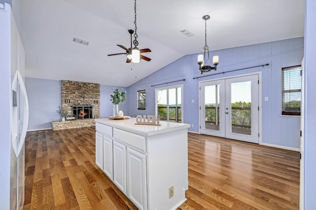 kitchen with visible vents, ceiling fan with notable chandelier, wood finished floors, open floor plan, and white cabinets