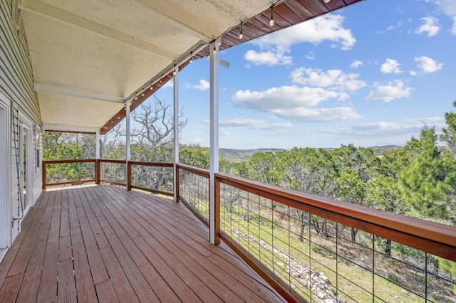 wooden terrace featuring a forest view