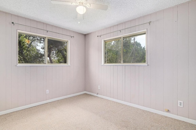 unfurnished room with baseboards, carpet floors, a textured ceiling, and a ceiling fan