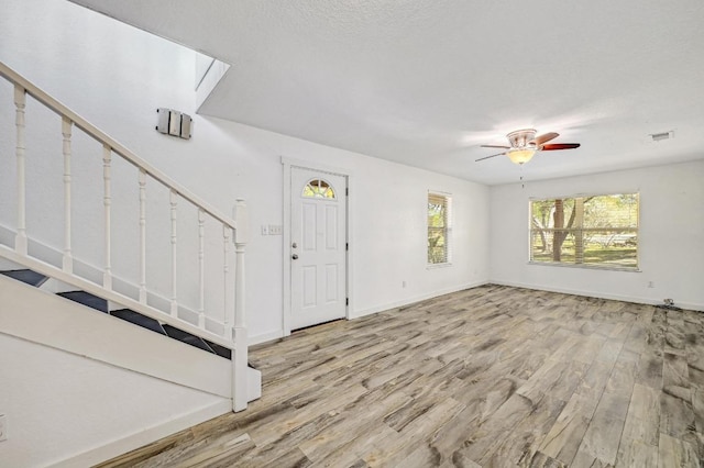 entrance foyer featuring stairs, wood finished floors, baseboards, and ceiling fan