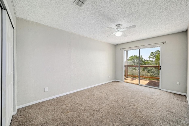 carpeted empty room with baseboards, a ceiling fan, visible vents, and a textured ceiling