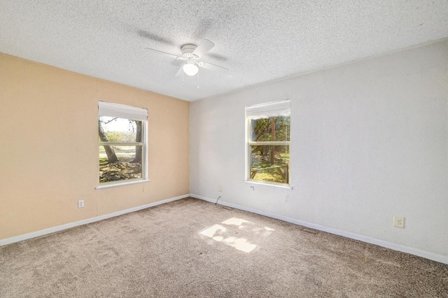 carpeted empty room featuring baseboards, a textured ceiling, and a ceiling fan