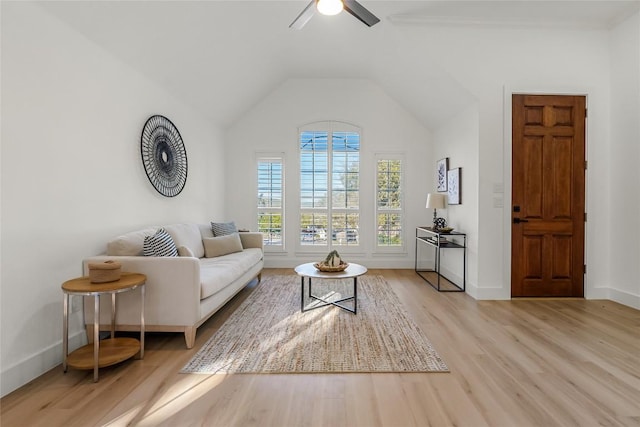 living area featuring a ceiling fan, vaulted ceiling, baseboards, and wood finished floors