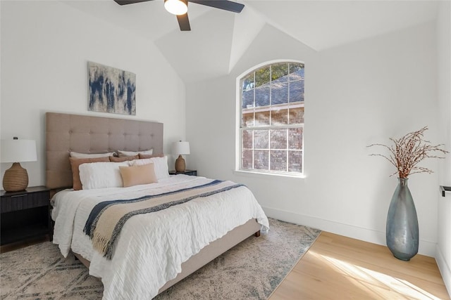 bedroom with ceiling fan, baseboards, vaulted ceiling, and wood finished floors