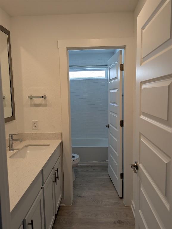 bathroom with vanity, wood finished floors, and toilet