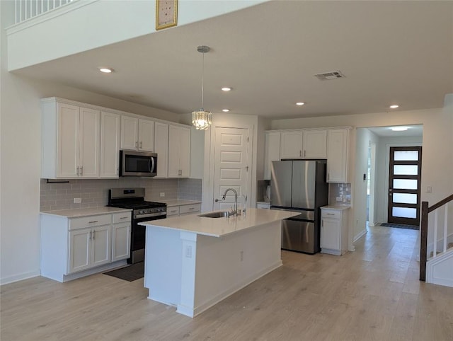 kitchen featuring white cabinetry, visible vents, stainless steel appliances, and a sink