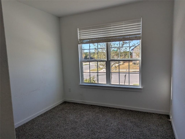 carpeted empty room featuring baseboards