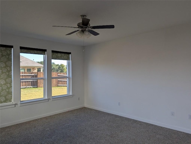 carpeted empty room with baseboards and a ceiling fan