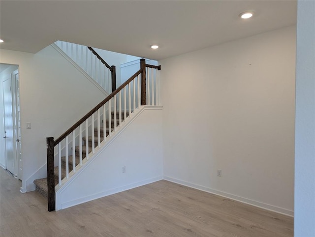 stairway featuring recessed lighting, baseboards, and wood finished floors